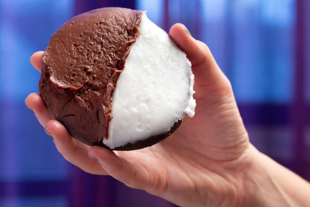 A person's hand holding a Half Moon Cookie. 