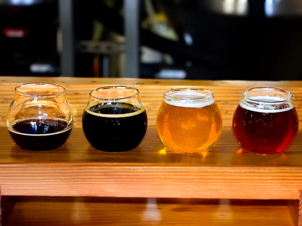 A flight of beer in short, round glasses. 