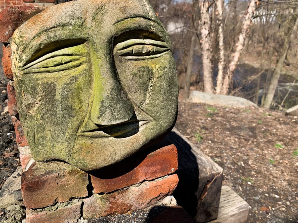 Whimsical face carved into a large stone.