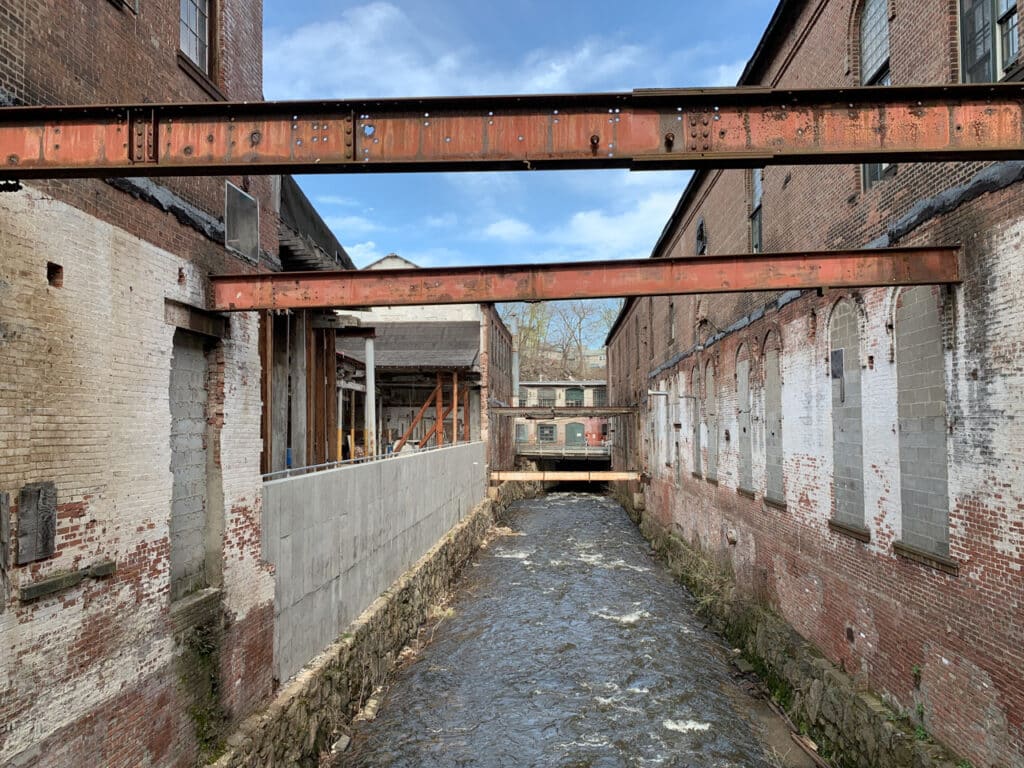 A creek running through the property of an old, brick factory.