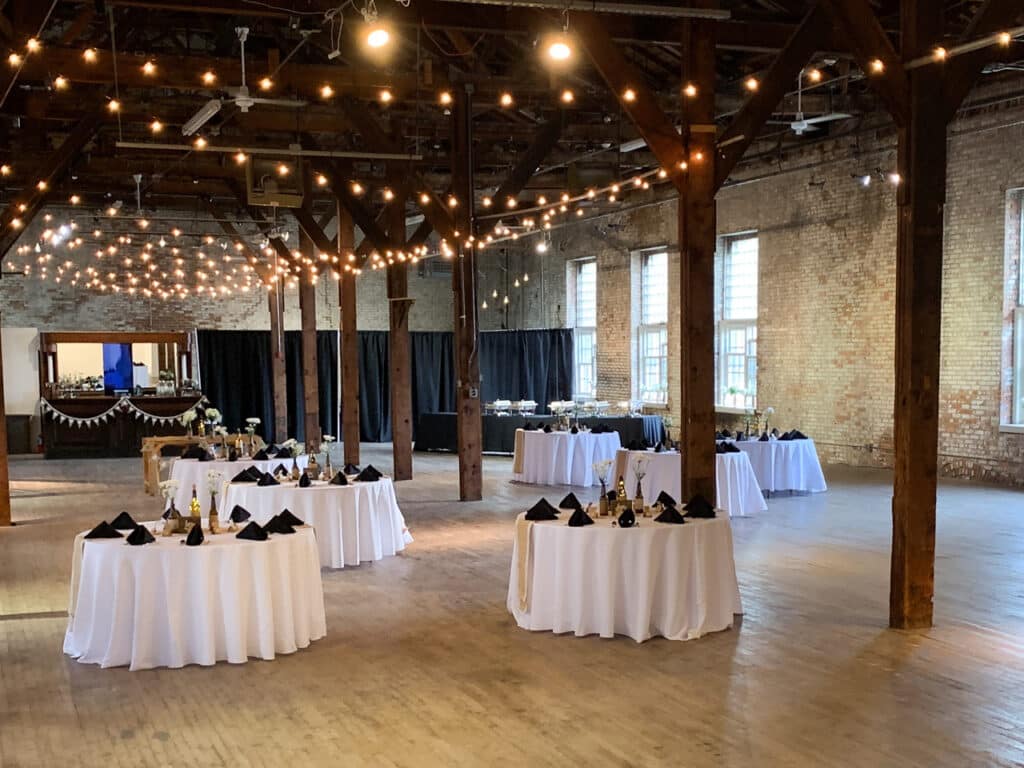 A large industrial room that is decorated for a wedding.
