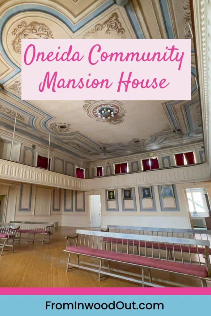 A large room with benches and painted ceiling, inside Oneida Community Mansion House.