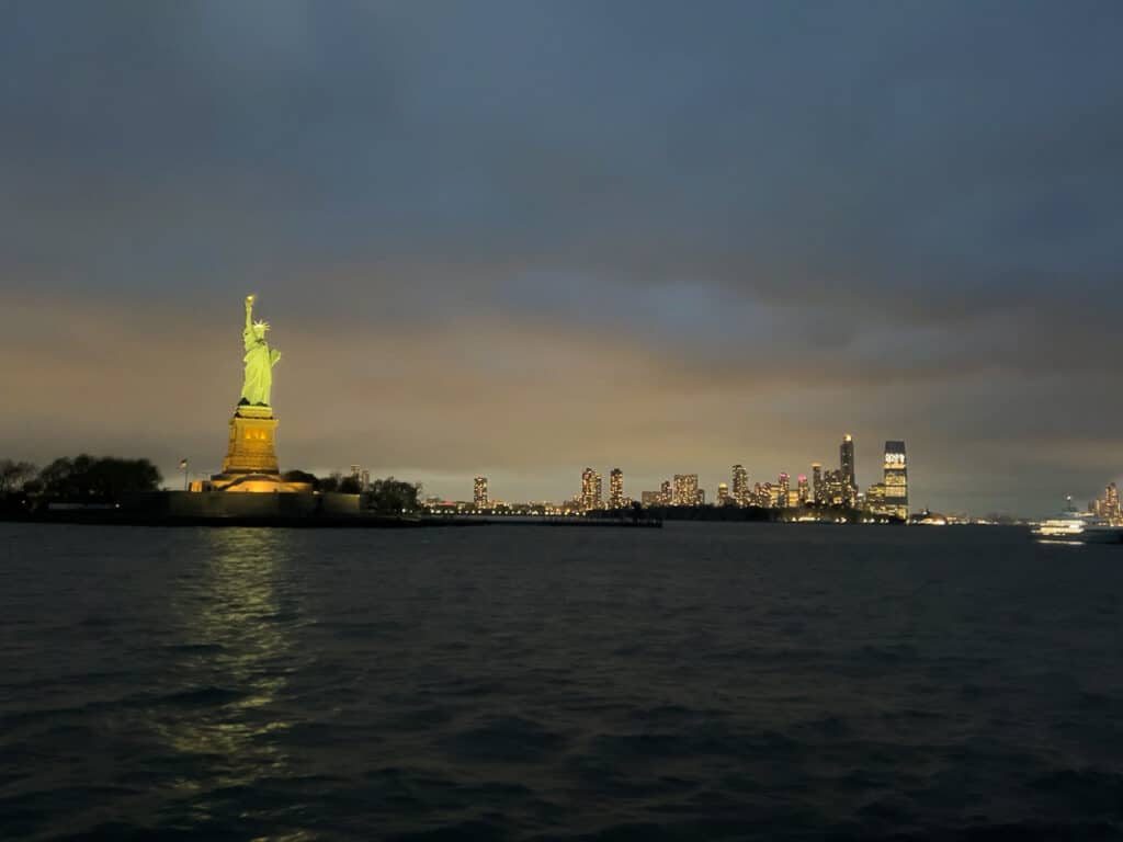 The Statue of Liberty in the distance, just after sunset.