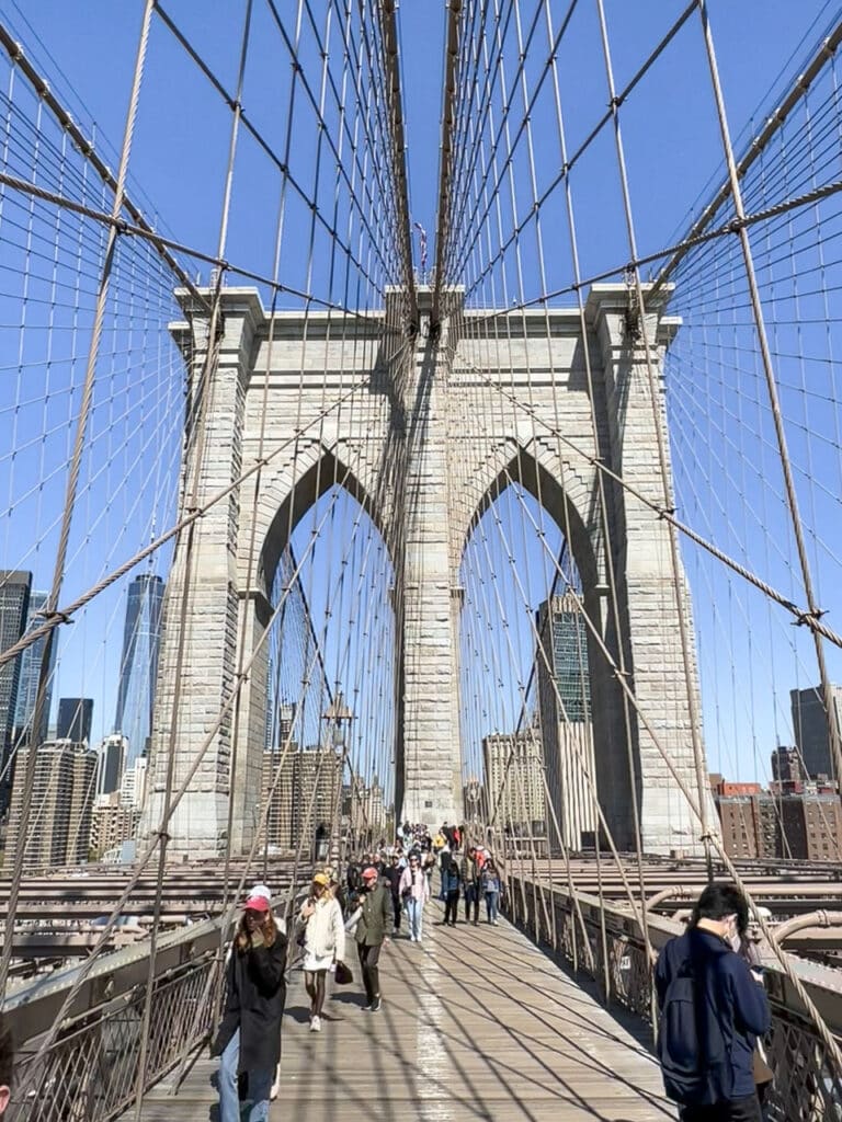 People walking across the Brooklyn Bridge in New York City.