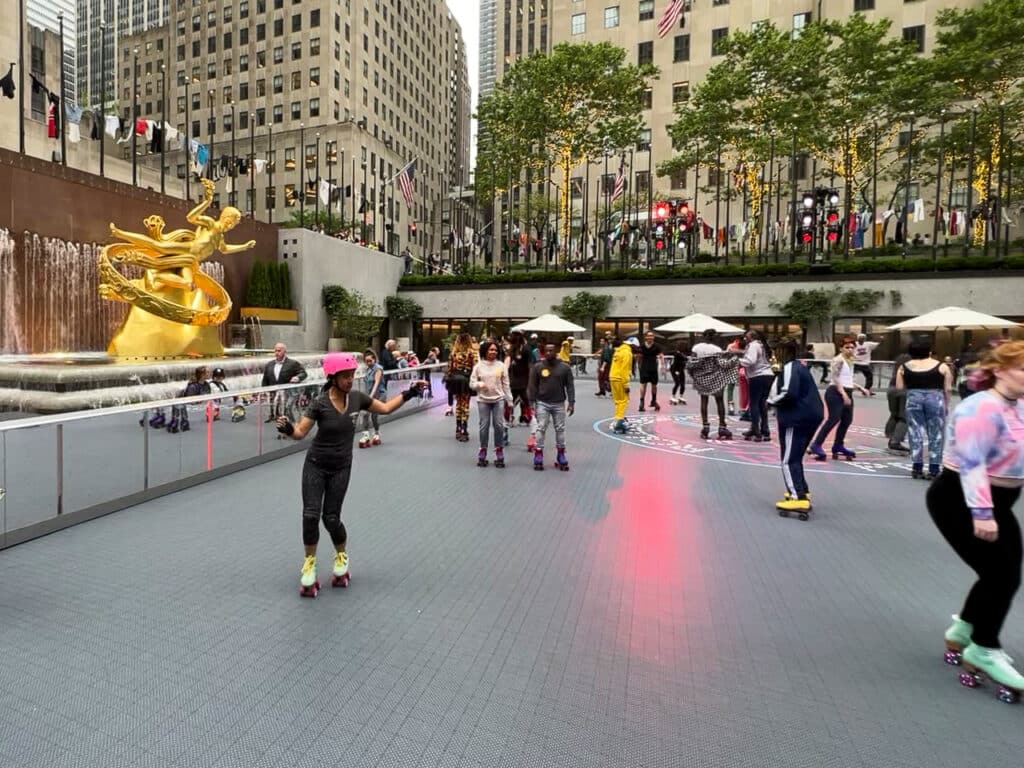 People roller skating on the rink at Rockefeller Center in New York City.