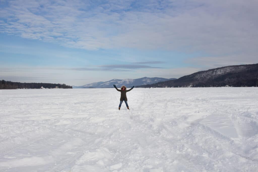 Person standing on a frozen, snow-covered lake.