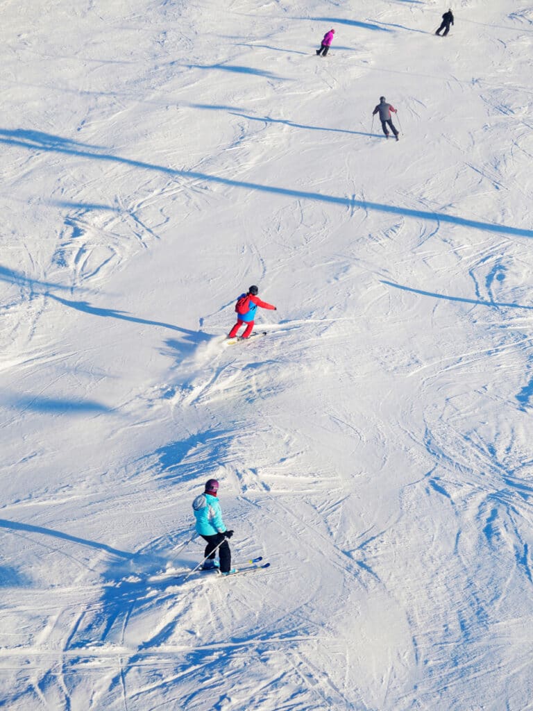 Downhill skiers scattered across a ski slope.