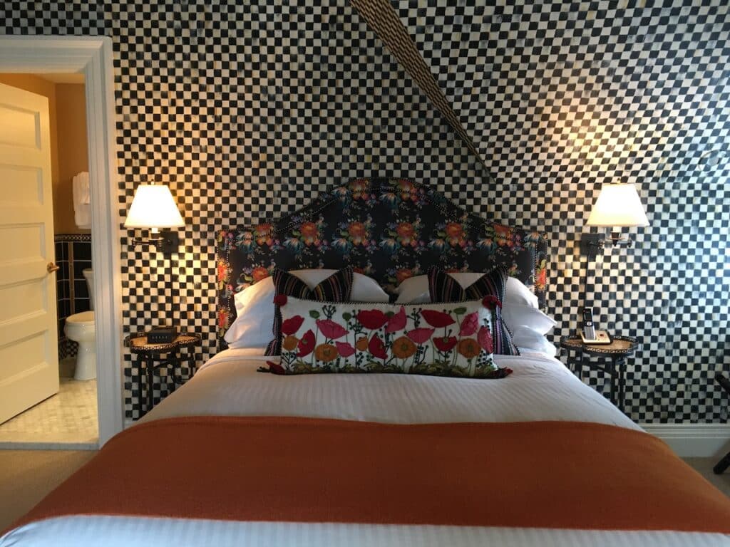 A guest room in a bed-and-breakfast whose walls are decorated in a checkered black-and-white pattern.